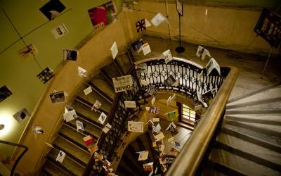 Image is of the Architecture and Planning Library stairwell, which is a winding stairwell with chandeliers made of postcards.