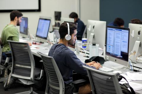 Student wearing headphones in front of a computer