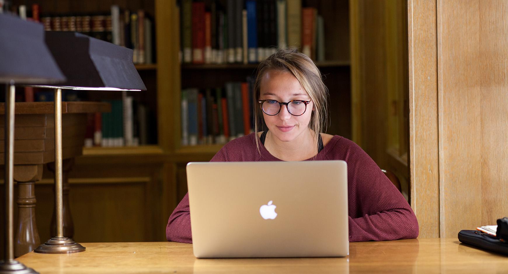 student using mac laptop in the architecture and planning library