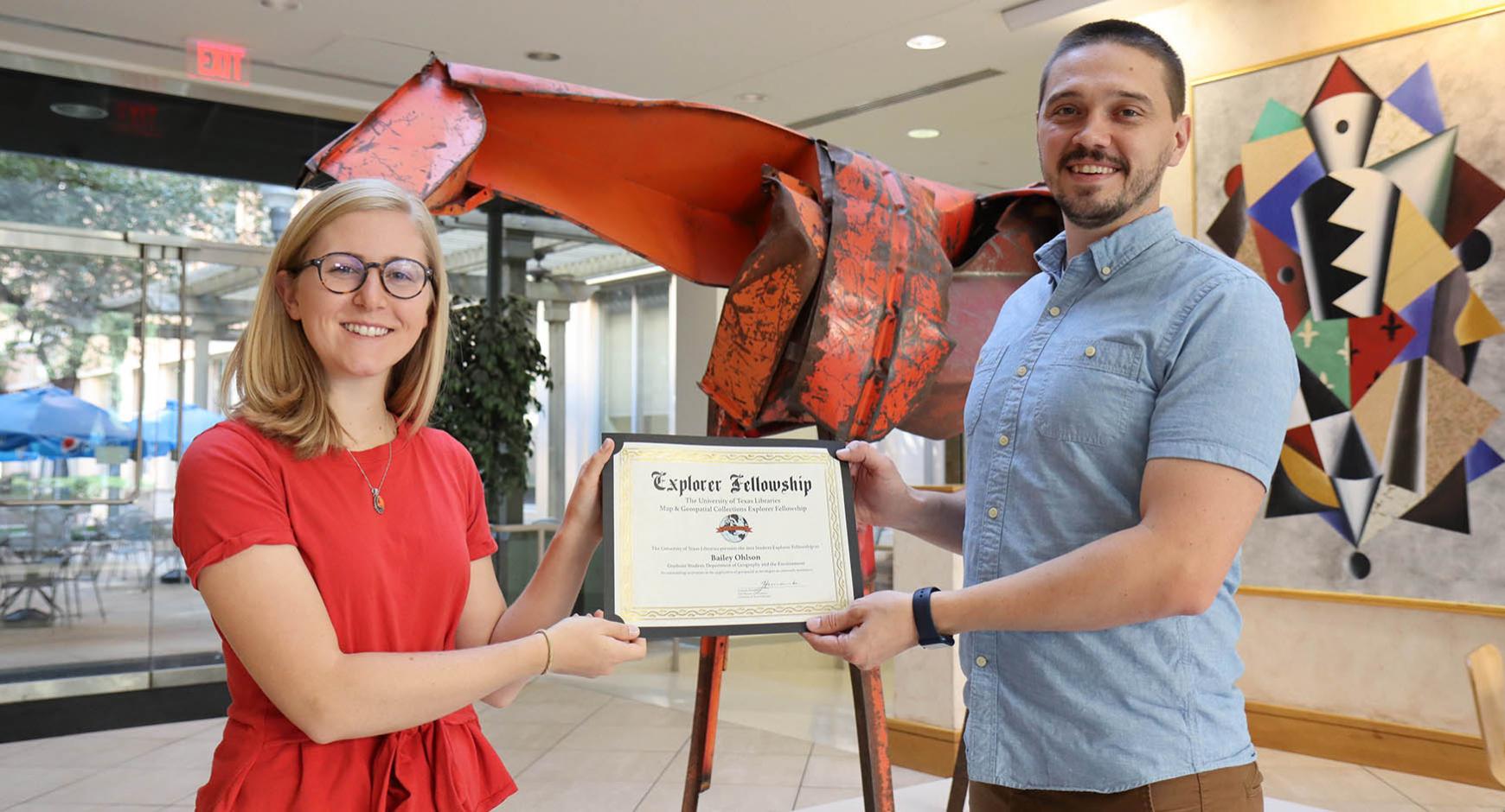 geography graduate student bailey ohlson receiving award from IS and Geospatial Data Coordinator michael shensky