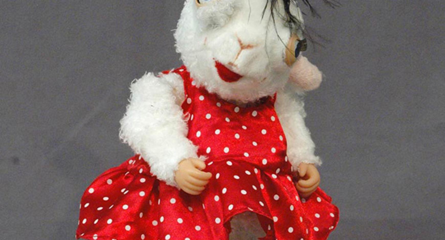 Photograph of "Herstory," an animatronic doll wearing a red polka dot dress with human like hands, created by Russian multimedia artist Yuliya Lanina, intended to portray alternate realities fusing fantasy, femininity, and humor.