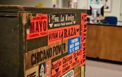 A wooden container with a mix of stickers with phrases