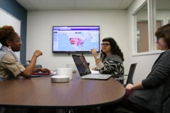 Three students discussing a project in a reserved room