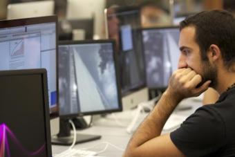 students at a computer staring at a monitor