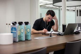 A student at a table with charging station and laptop