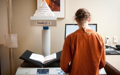 Student in front of a book scanner