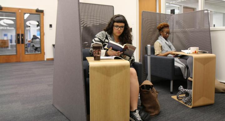 Two students in comfortable seating with portable desks