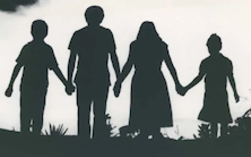 Four people walking in silhouette
