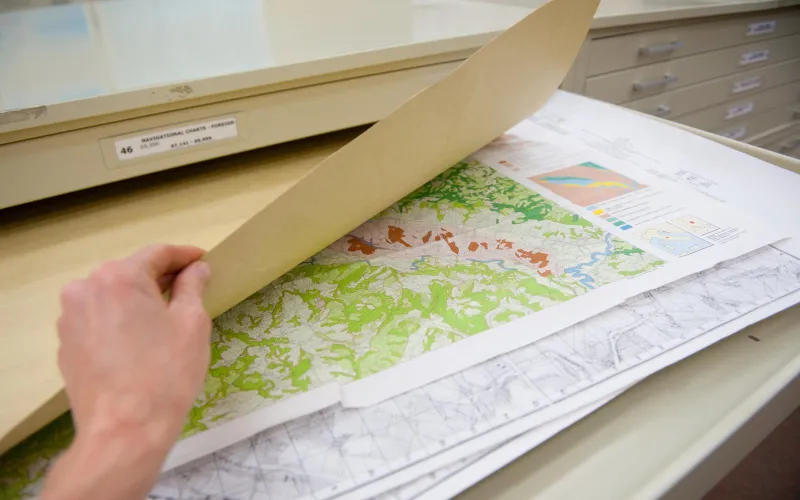 A person thumbing through maps in the ppl